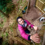 Woman climbing rope ladder at Go Ape Aberfoyle in Scotland.