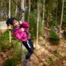 Woman on skateboard zipwire at Go Ape Aberfoyle in Scotland